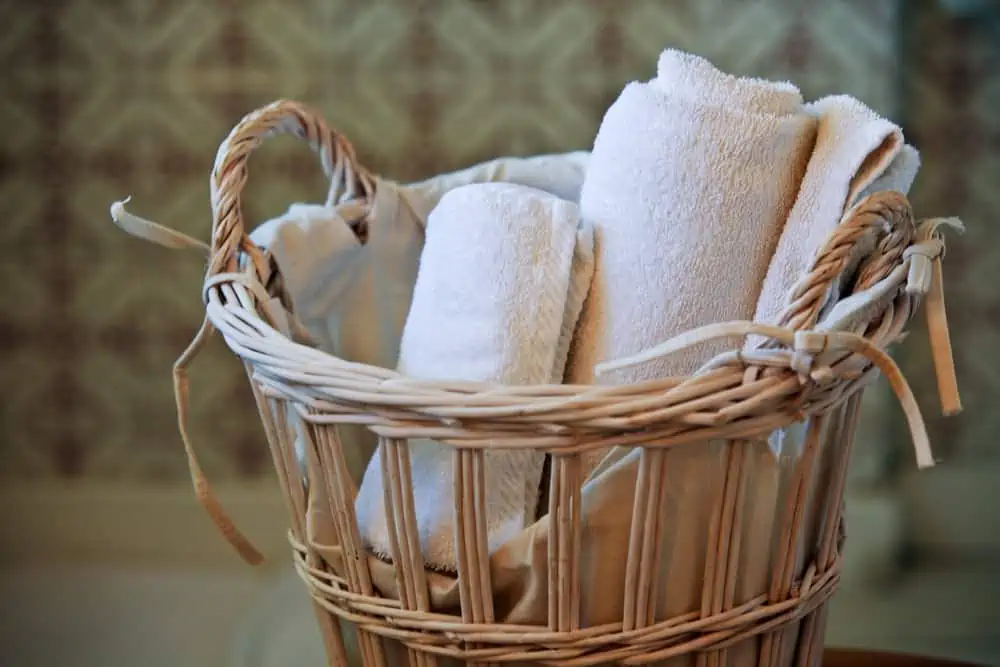 two white rolled towels in wicker basket