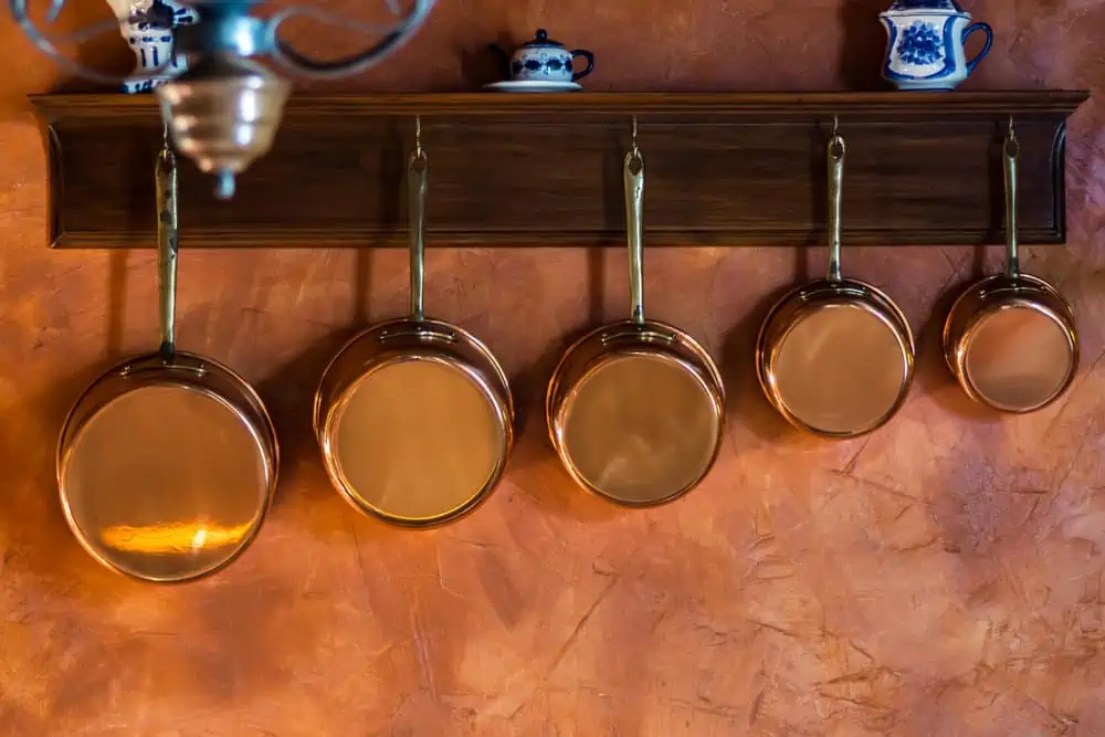 Copper saucepans hanging on wall